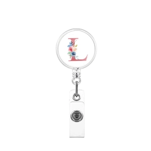 Close-up of retractable badge reel featuring a floral letter L design on a white surface
