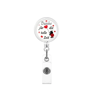 Detail of retractable badge reel with ladybug heart design and German gratitude text