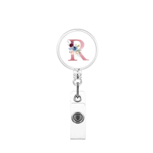 Detail of retractable badge holder featuring a floral letter R design and metal clip
