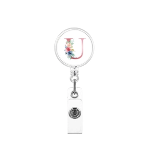 Close-up of retractable badge reel with floral letter U design and metal clip attachment