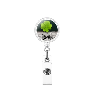 Close-up of retractable clover badge reel with a metal pull ring and clear plastic clip