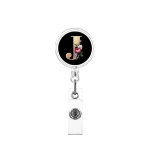 Macro detail of retractable badge reel featuring a floral letter J on a black base