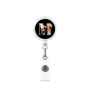 Close-up of retractable badge holder featuring a floral letter M on black background
