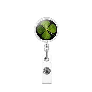Close-up of a retractable badge reel with a lucky four-leaf clover print and metal clip