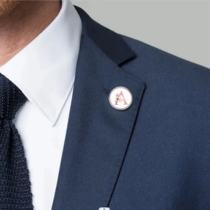 Detailed shot of an alphabet A brooch with floral accents on a navy suit lapel