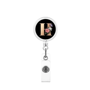 Detail of retractable badge holder featuring a black floral base and golden letter H