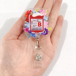 Retractable acrylic badge holder with B RH Negative blood bag and floral design