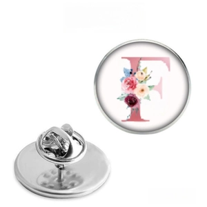 Detailed view of floral letter F badge with silver butterfly clutch pin backing