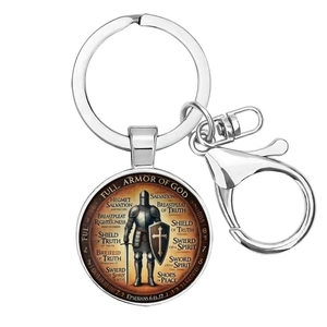 Close-up of Saint Benedict key ring with Full Armor of God scripture medal on white background