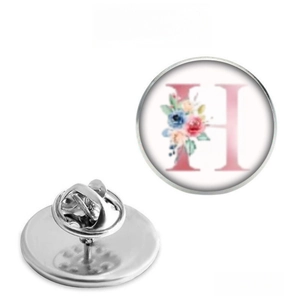 Detailed view of stainless steel brooch featuring pink letter H and floral pattern