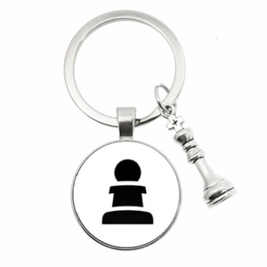 Macro detail of silver alloy chess keychain featuring pawn pendant and king piece charm