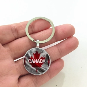 Gros plan d'un porte-clés argenté drapeau du Canada avec pendentif feuille d'érable