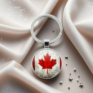 Gros plan détaillé d'un porte-clés drapeau du Canada sur un élégant tissu en soie beige