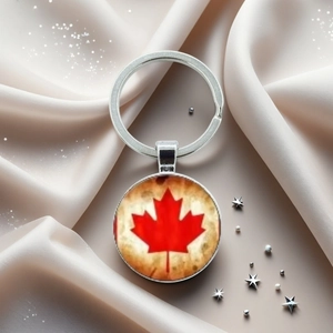 Détail d'un porte-clés feuille d'érable du Canada en argent sur un fond de satin doux