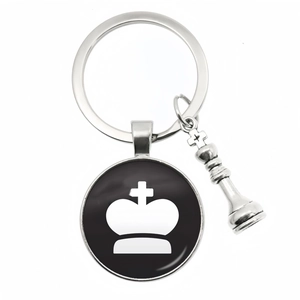 Macro detail of chess king keychain with silver metal pendant and glass crown cabochon