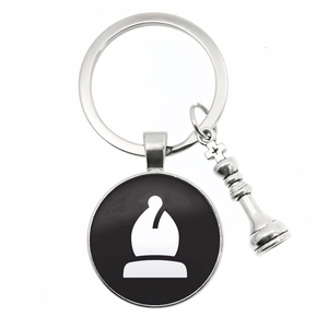 Detail of silver chess bishop pendant and small piece on a metallic keychain ring