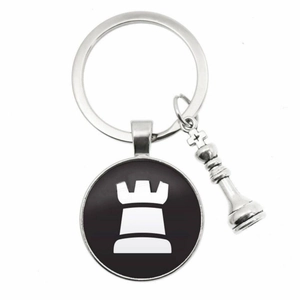Close-up of metal chess keychain with silver king charm and rook pattern pendant