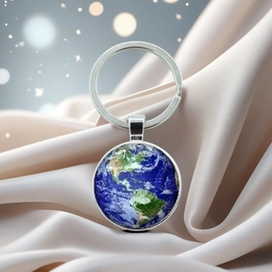 Detail of Earth planet pendant on a silver keychain with crystal dome and silk background