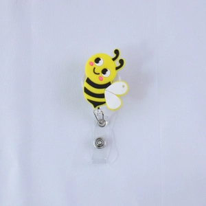 Dettaglio del porta badge retrattile a forma di ape in PVC giallo con clip in metallo