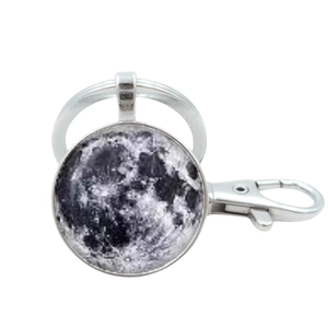 Close-up of silver metal keychain with moon pattern pendant and lobster clasp detail