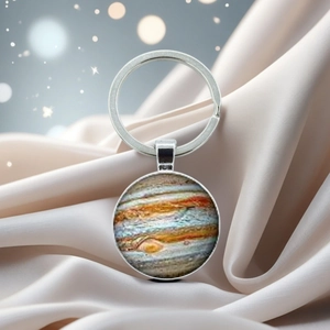 Macro shot of Jupiter planet crystal keychain on luxury satin with bokeh lighting effects