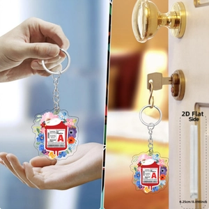 Detail view of 2D acrylic blood bag keychain with floral patterns and thickness scale