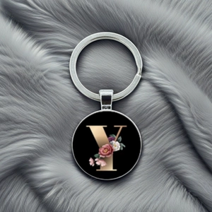 Macro shot of silver metal keychain with floral letter Y charm on grey plush background