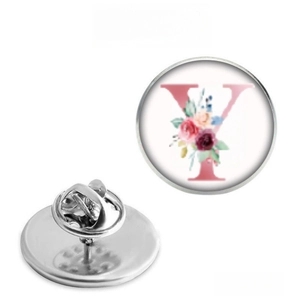 Detailed view of silver metal round brooch with pink floral letter Y and butterfly clutch