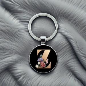 Detailed close-up of a metal keychain with a floral gold letter Z on a plush background