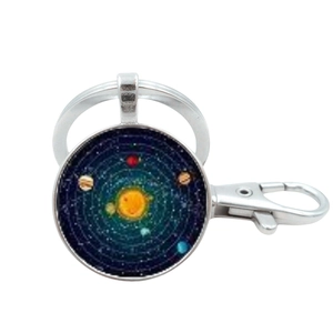 Detail of silver metal keychain with circular solar system glass pendant and lobster clasp