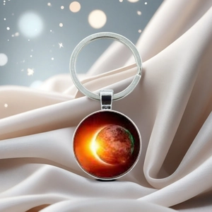 Detailed view of planetary glass dome keychain with solar eclipse design on silk fabric