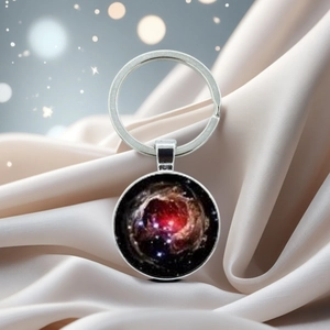 Macro shot of solar system nebula glass cabochon pendant on a silver metal keychain