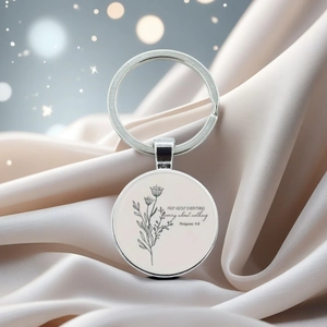 Detail of silver scripture keychain with inspirational text on soft silk fabric