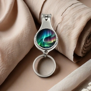 Polished metal nail clipper keychain with colorful northern lights glass dome decor