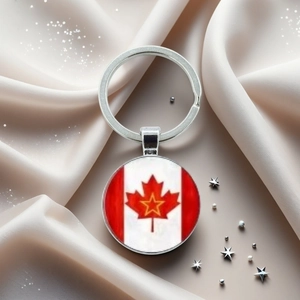 Détail du porte-clés drapeau canadien argenté avec feuille d'érable rouge sur fond velours