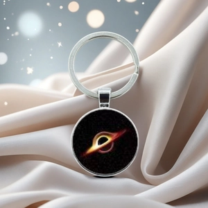 Macro shot of silver metal keychain with a deep black hole accretion disk pendant