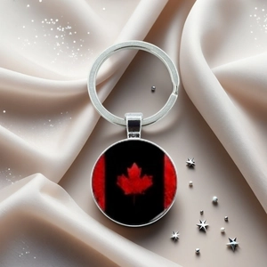 Vue à plat d'un porte-clés drapeau Canada argenté avec feuille d'érable sur soie