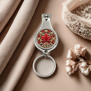 Detailed view of silver Canada flag nail clipper keychain with red maple leaf on lace fabric