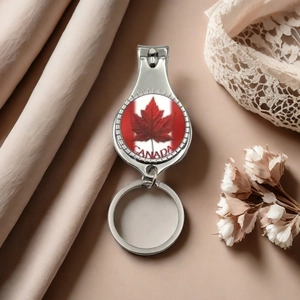 Macro detail of a Canada maple leaf nail clipper keychain on a decorative white lace background