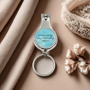 Polished stainless steel nail clipper keychain with inspirational quote on blue pattern