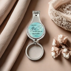 Macro view of motivational nail clipper keychain with blue watercolor design and silver finish