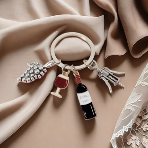 Macro detail of wine theme keychain with grape, wine glass, bottle and opener charms