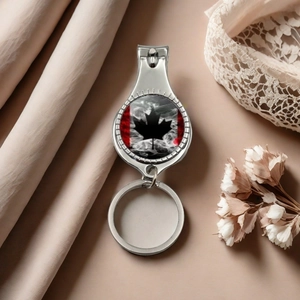 Detail view of Canadian flag maple leaf nail clipper and bottle opener keychain on silk