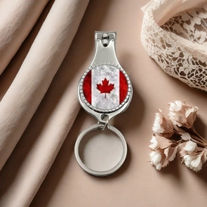 Detail of Canadian flag nail clipper and keychain on soft silk background