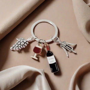 Creative wine themed keychain with grape, bottle and opener charms on silk background