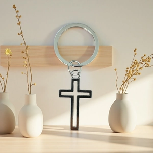 Gros plan d'un porte-clés croix en métal argenté dans un décor de maison moderne
