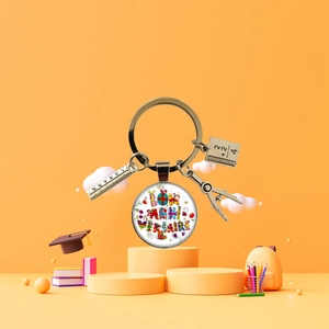 Vista macro di un portachiavi di laurea con ciondoli a forma di righello, taccuino e compasso