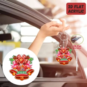 Detailed macro view of 2D flat acrylic Christmas bell keychain with festive red bow