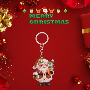 Close-up of 2D acrylic Christmas Santa Claus and snowman keychain on festive background