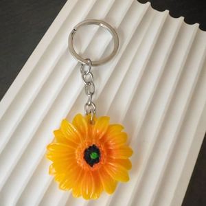 Portachiavi girasole con petali in resina gialla e anello in metallo argentato su base bianca